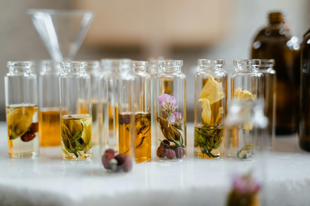 Strained herb-infused olive oil in a glass bottle ready for soap making