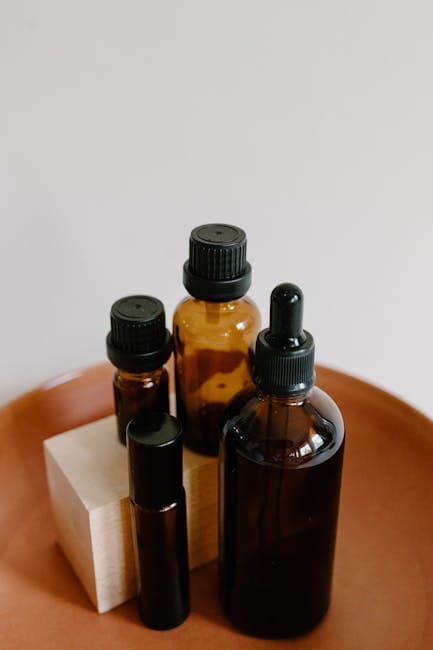 Close-up of tea tree leaves next to a bottle of essential oil