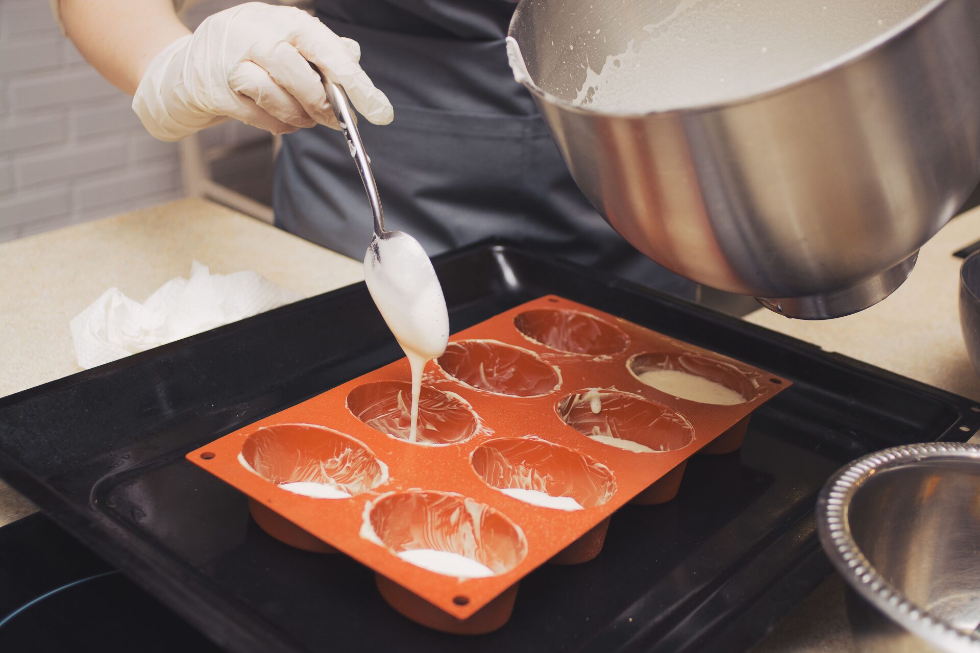 Pouring soap batter into a loaf mold to build a layer