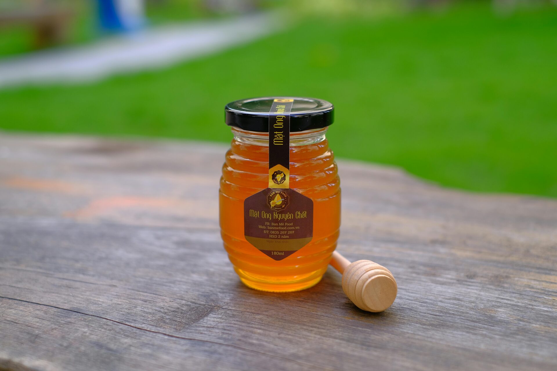 Raw honey in a jar with a wooden dipper